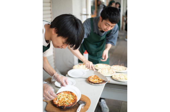 ピザを盛り付ける学生の写真