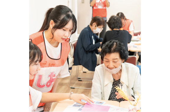 学生と一緒に折り紙をしている写真