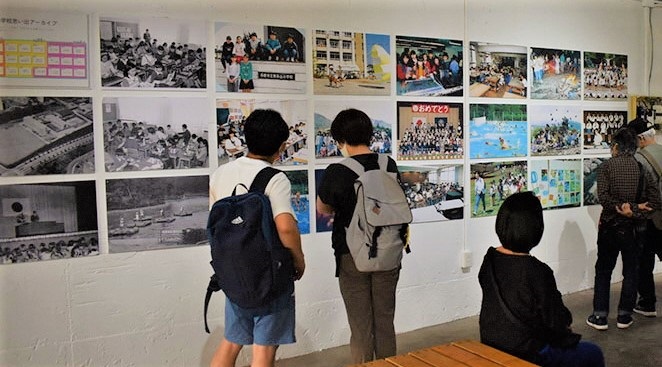 東永山小学校の写真展示と観覧する人々