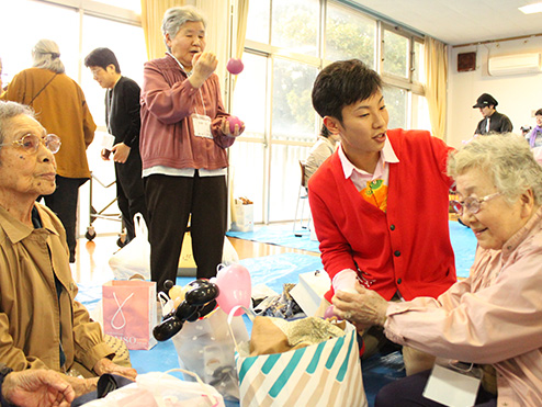 第八回茶話会 （これから茶話会 お花見会）で手品を楽しむ高齢者