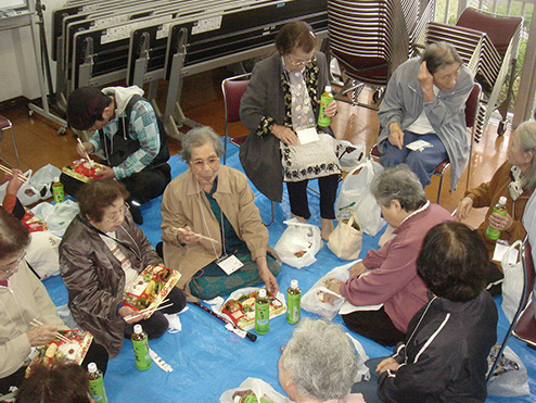第八回茶話会 （これから茶話会 お花見会）でお弁当を食べながら団らんする参加者