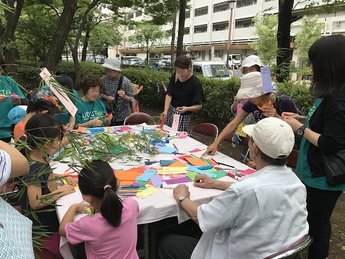 子どもたちや住民が七夕かざりづくりをしている写真