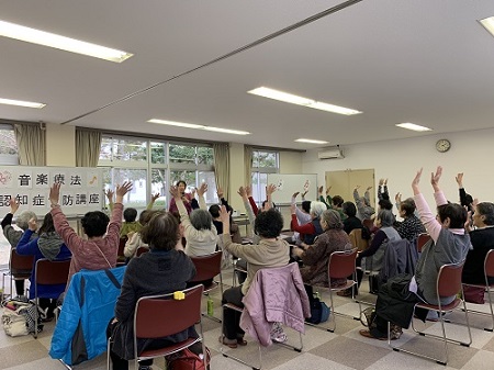 先生の熱心な指導で参加者が音楽に合わせて手を挙げて運動している写真