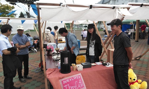 地域カフェの店員がコーヒーを入れている写真