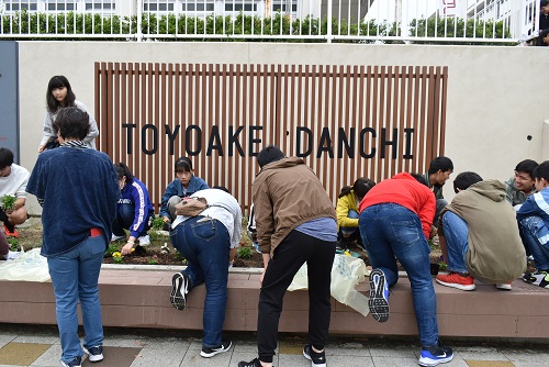 参加者が花を植えている写真