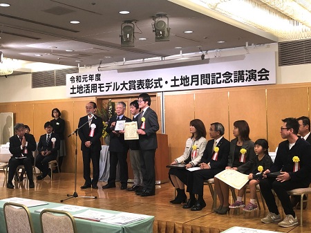 受賞式でひな壇に集合する受賞者の写真