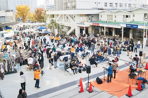 たくさんのお客さんでにぎわっているイベント広場の写真