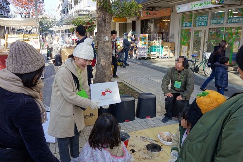 火おこしワークショップで学ぶ参加者の写真