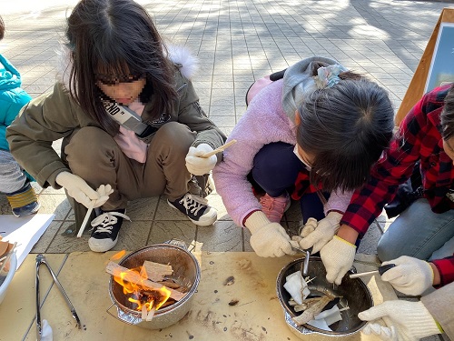 子どもたちが火おこしをしている写真