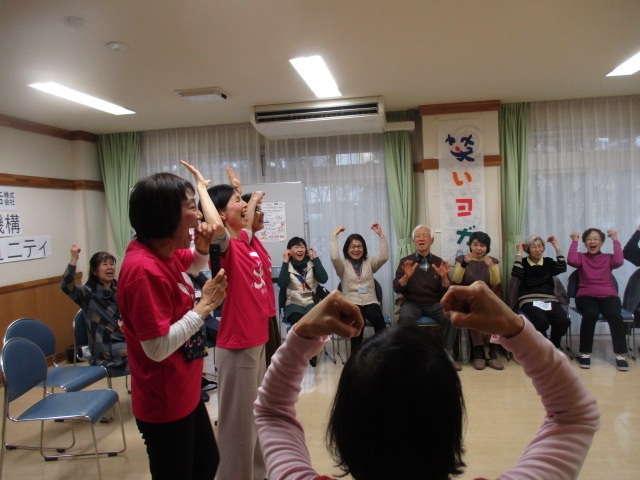 手を挙げながら大笑いする練習をしている参加者の写真