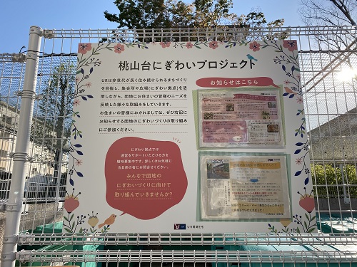 桃山台にぎわいプロジェクトと書かれた掲示板が金網に掲示されている写真