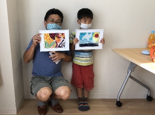 お父さんと子供が完成した作品を持ってポーズをとっている写真