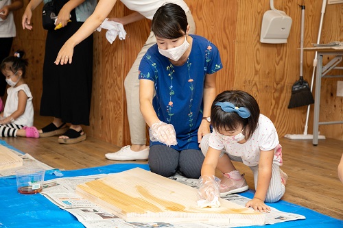 参加者の親子が机をやすりで削っている写真