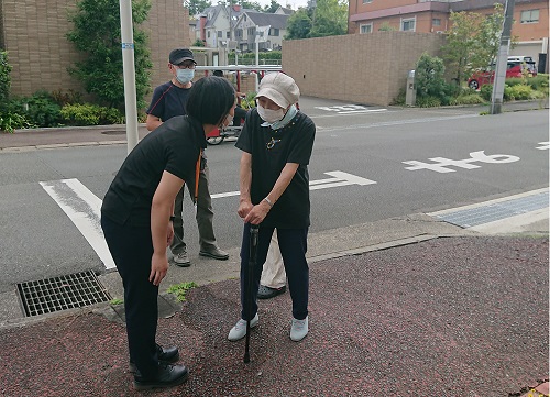 歩道で参加者に声をかける地域包括支援センターのスタッフ