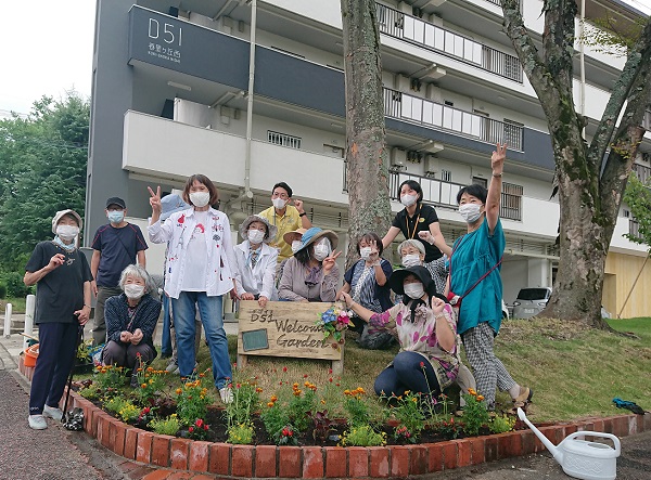 花壇の囲んで参加者の集合写真