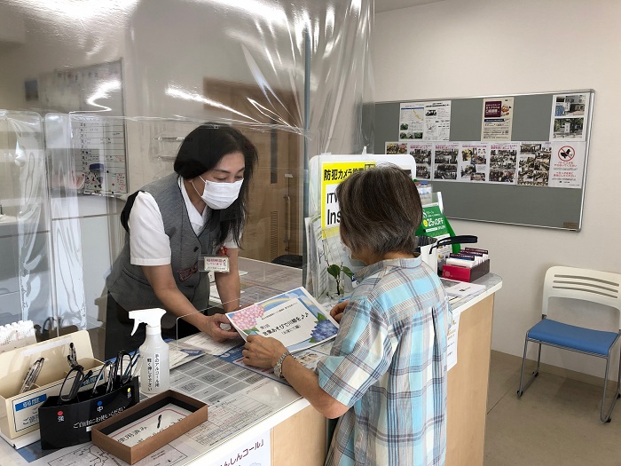 住まいセンターでで応募作品の冊子を受け取る住民の写真