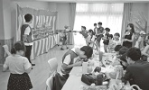 夏休みの子どもたちが団地の集会所で楽しんでいる様子