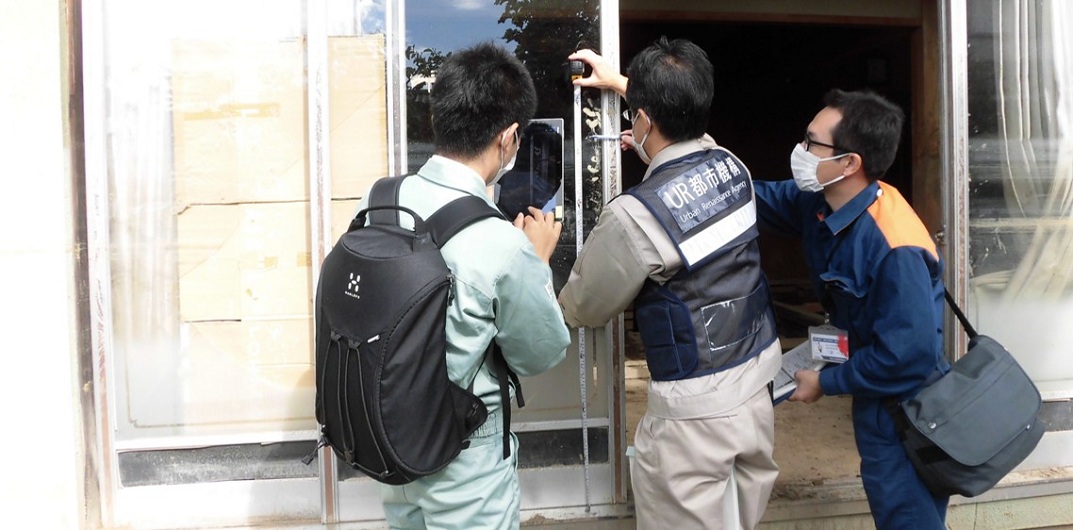 窓ガラスやサッシに損傷が見られ、災害による破損状況を調査している様子。