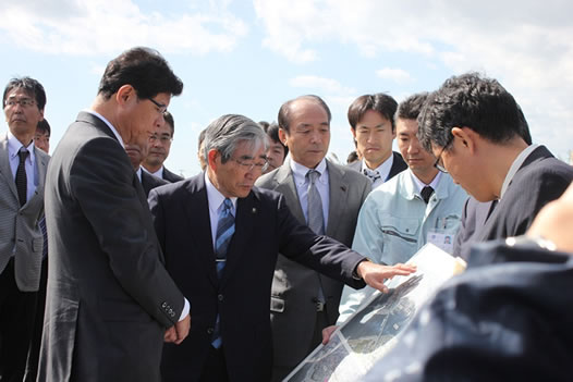 写真：亀山市長（中央）から地区の説明を受ける高木大臣