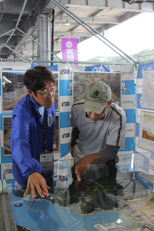 写真:町のジオラマを見ながら熱心に質問される来場者