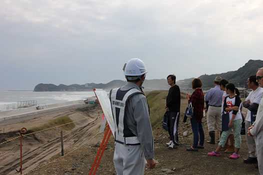 写真:盛土の上に整備される防災緑地から豊間の海岸を眺める参加者のみなさん
