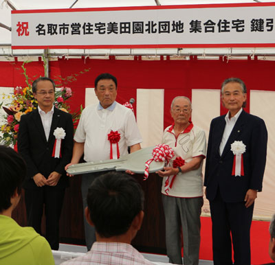 鍵の引渡しの様子。稲垣本部長から佐々木市長へ、その後入居者代表高橋さん（中央左）、竹内さん（中央右）へ鍵が引渡しされました