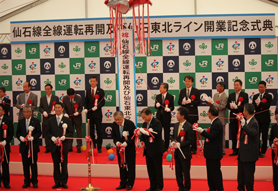 写真：くす玉開披を行う花岡　洋文副理事長（上段右から４番目）