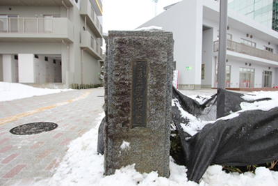 写真：「気仙沼立南気仙沼小学校」と刻まれた校門の御影石。地区内南側の通路と北西のカドニワに設置されています1