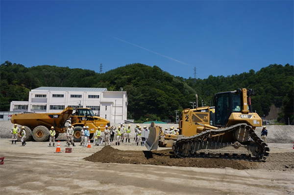 写真：施工実演　重ダンプで運んだ土砂をブルドーザーで敷き均します。