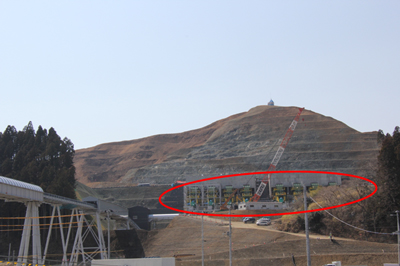 写真：破砕機（赤丸）と造成する高台。破砕機のところまで山を切ります