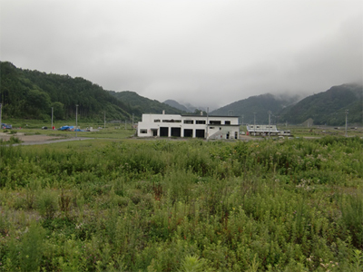 被災した釜石市鵜住居地区。ＪＲ山田線「鵜住居」駅から多くの方が犠牲になった防災センターの方角を臨む（平成25年7月26日撮影）