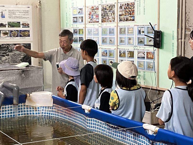 養殖施設で陸上養殖の管理業務について学ぶ子どもたち